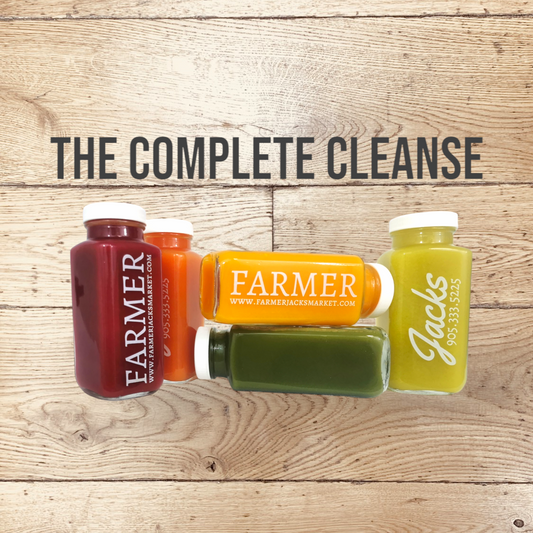 Farmer Jack's Complete Cleanse image - 5 gleaming glass bottles, stamped with Farmer Jack's branding, which pops against the brightly coloured juices within them.
