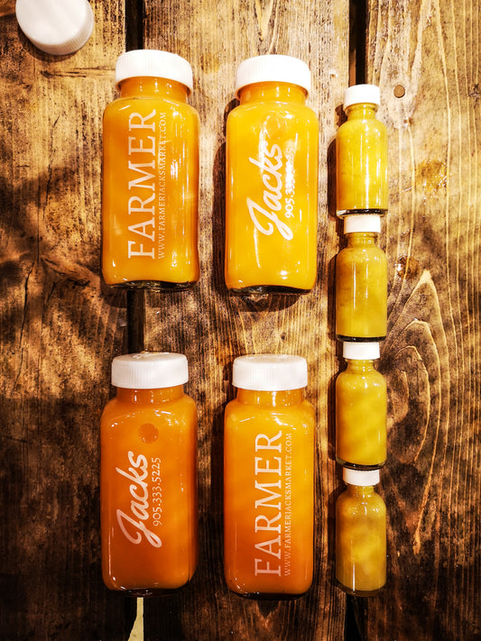 Farmer Jack's Booster Pack - 4x 250ml glass bottles of bright orange Immunity Booster juices, and 4x 1oz bottles of bright yellow Flu Shots.